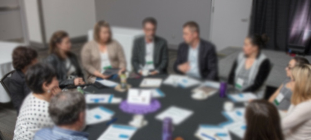 group of people sitting around a round conference table